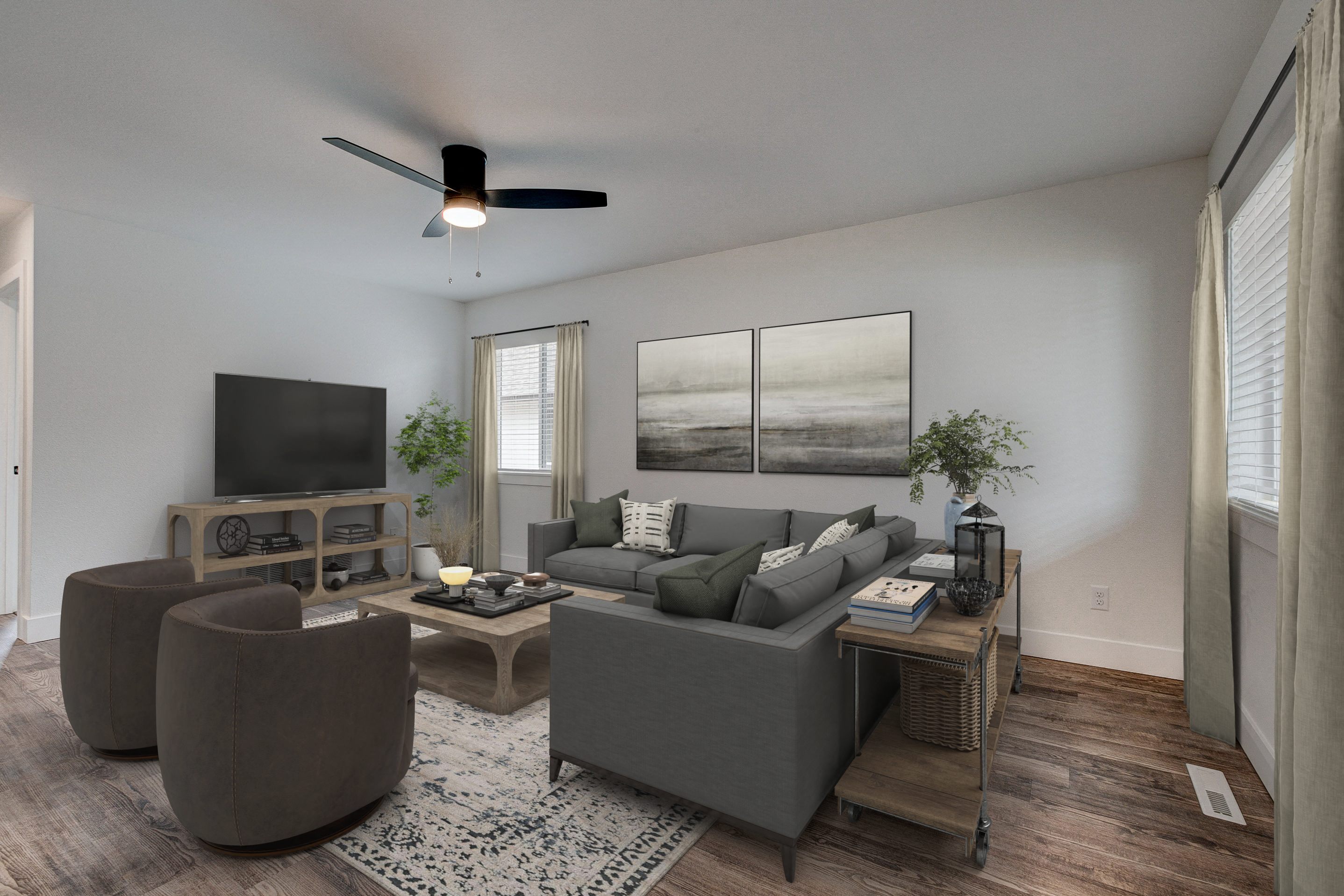 A living room with a grey couch, a brown ottoman, a coffee table, a television, and a ceiling fan.
