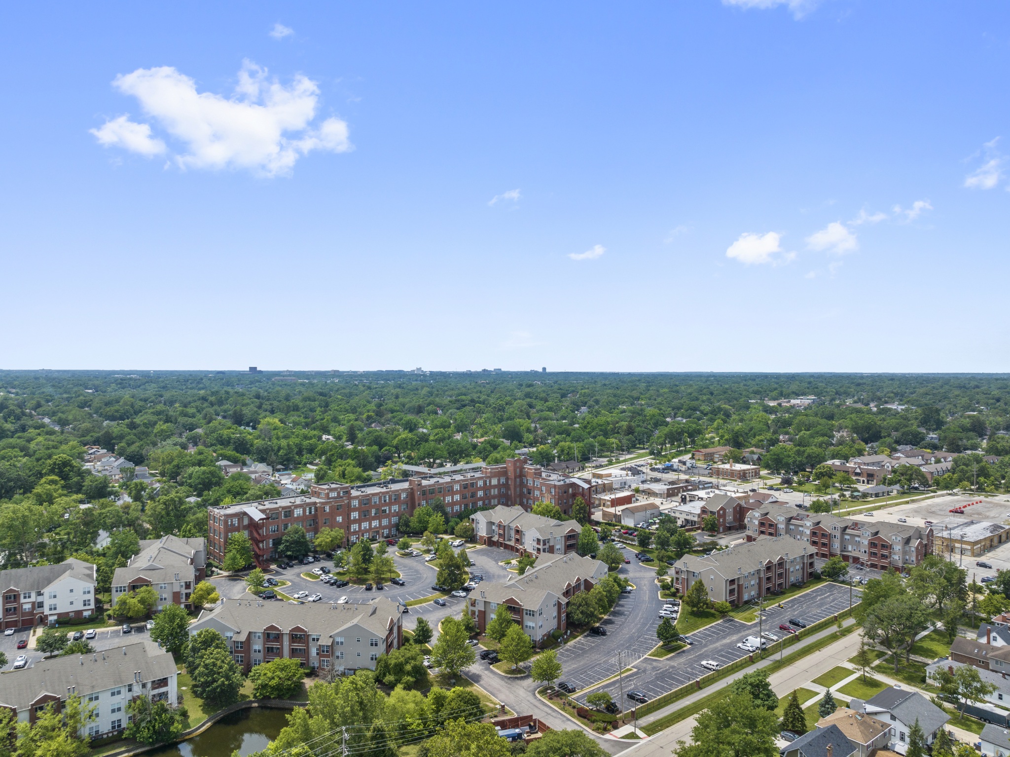 A view of a residential area with apartment buildings and a parking lot.