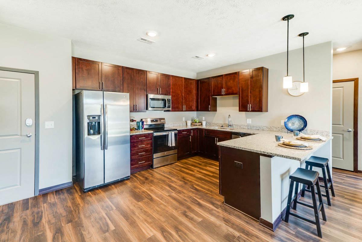 360 at Jordan West apartments A kitchen with wooden floors and a white island.