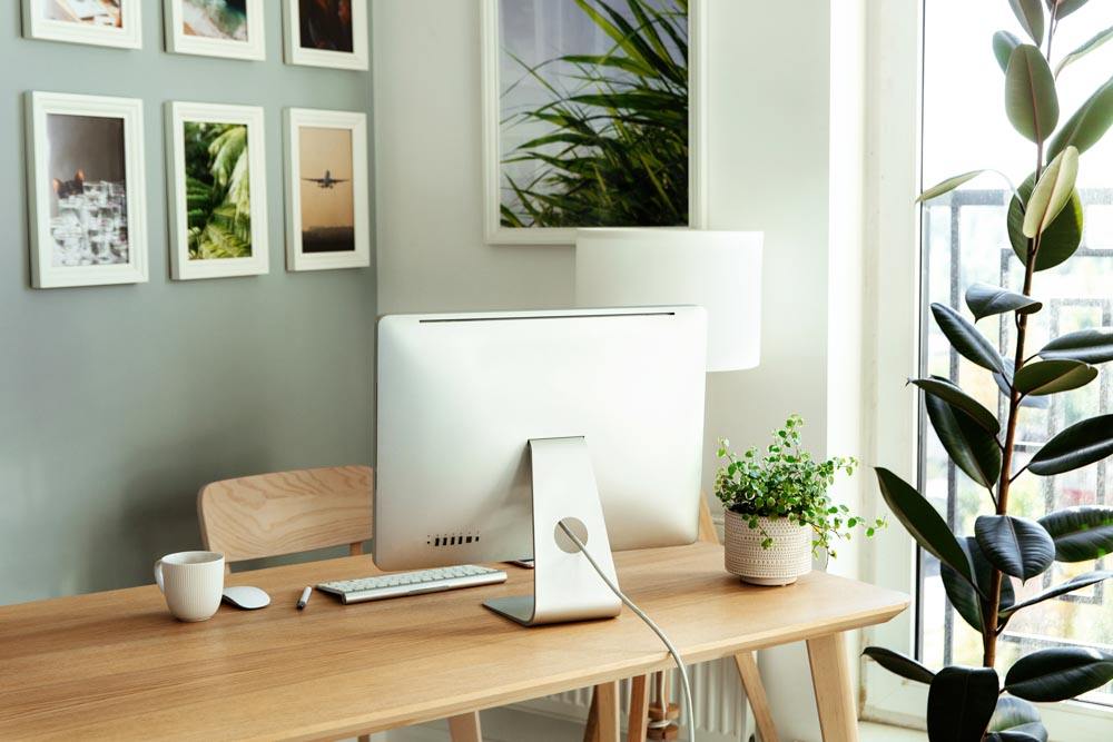 A work from home setup in an apartment with a wood desk and large monitor