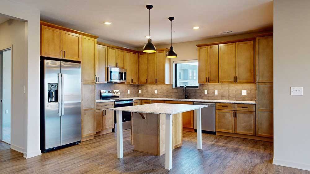 A kitchen with wooden cabinets and a granite countertop