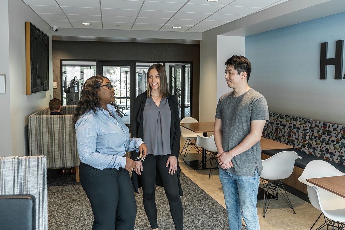 A leasing agent is showing a couple around an apartment during a tour