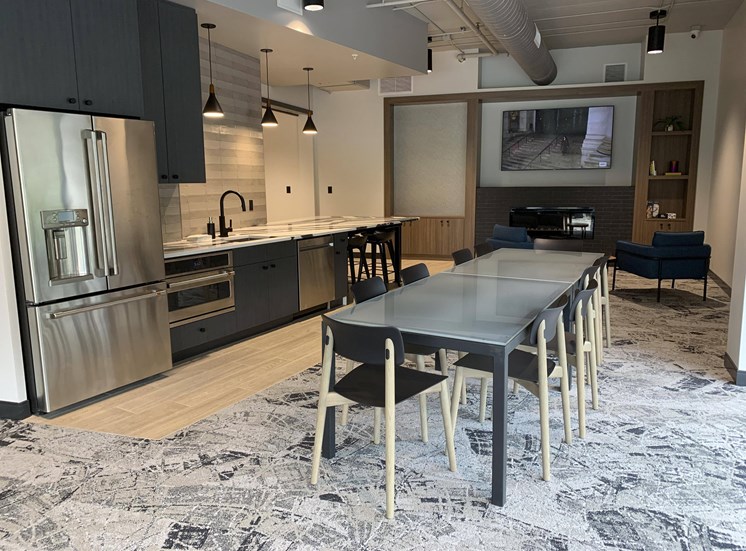 community room with lounge areas, TVs, and kitchen for entertaining