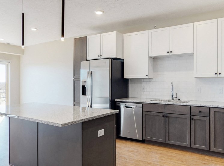 Beautiful kitchen completed with two tone slate finishes, including pendant lighting and stainless steel appliances in the Bliss floor plan at Haven at Uptown in Lincoln, NE
