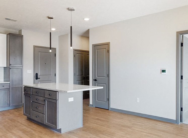 Pendant lighting and island providing seating in the Bliss floor plan kitchen at Haven at Uptown in Lincoln, NE