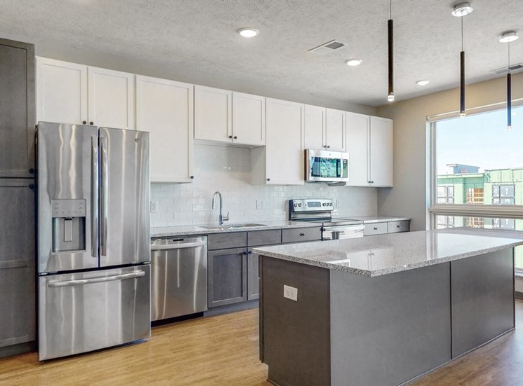 Large windows filter abundant natural light into the spacious kitchen in the Melody floor plan at Haven at Uptown in Lincoln, NE