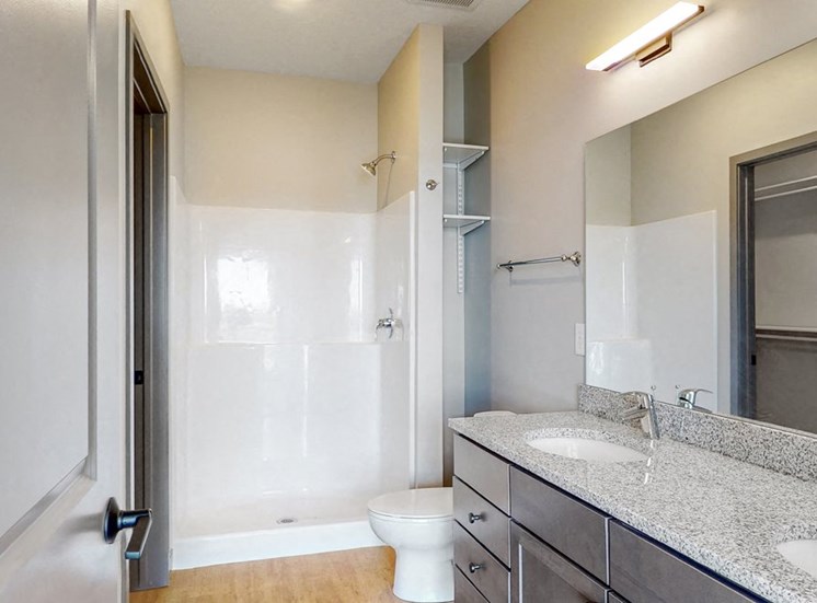View of dual sink counter tops and shower in bathroom attached to the master bedroom at Haven at Uptown in Lincoln, NE