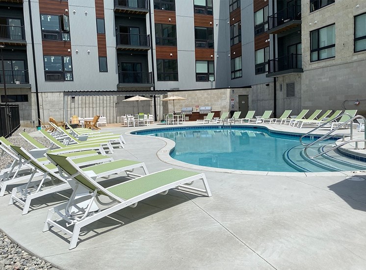 Light green lounge chairs near the luxury resort pool outside Haven at Uptown.
