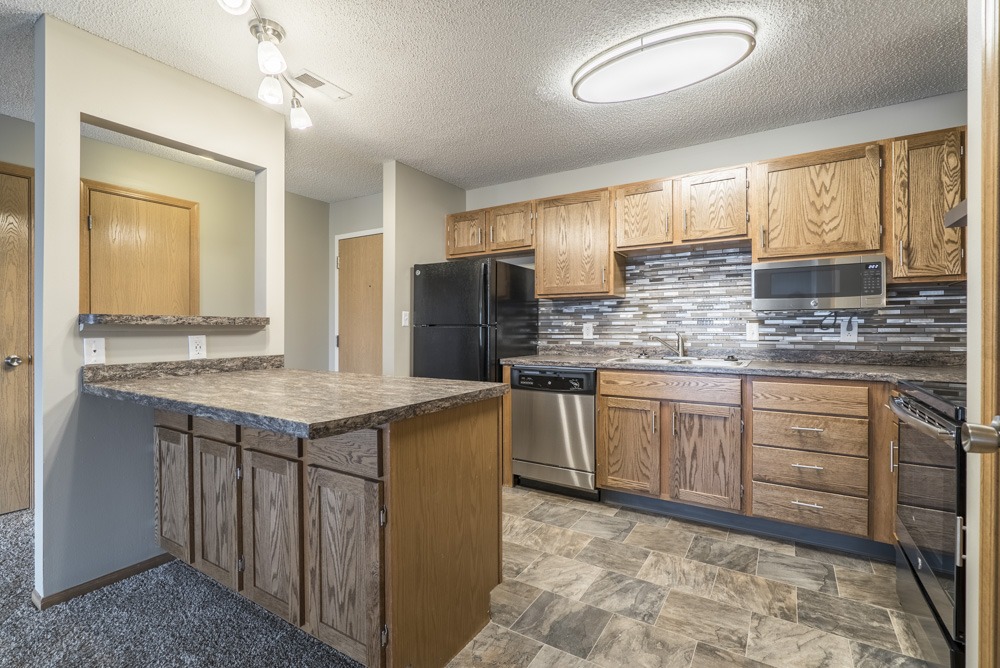 Renovated kitchen with tile backsplash and new appliances