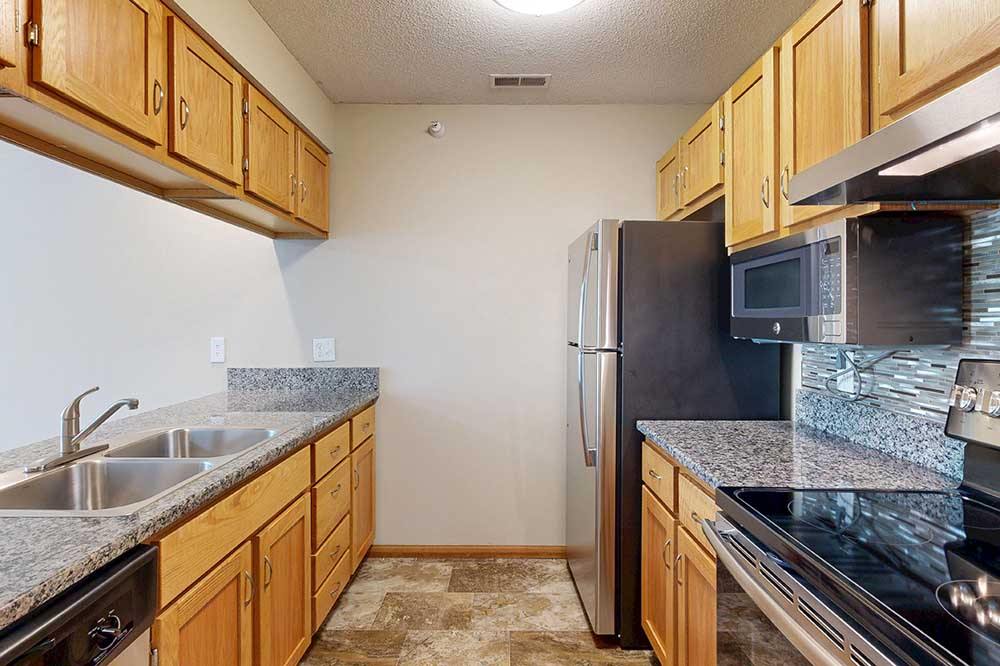 A kitchen with granite countertops and stainless steel appliances