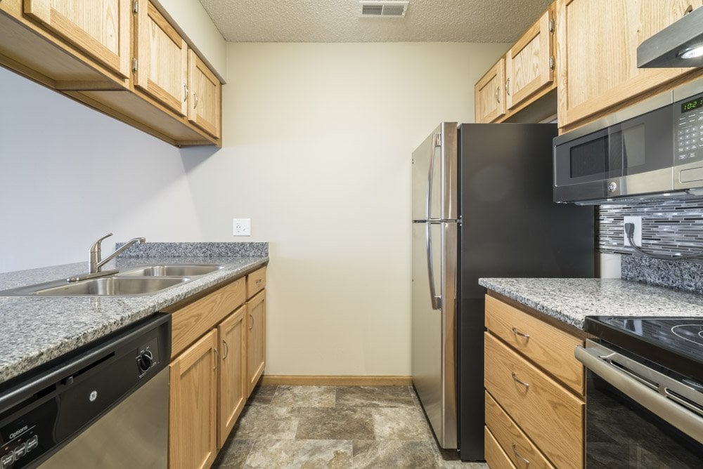 A kitchen with granite countertops and stainless steel appliances