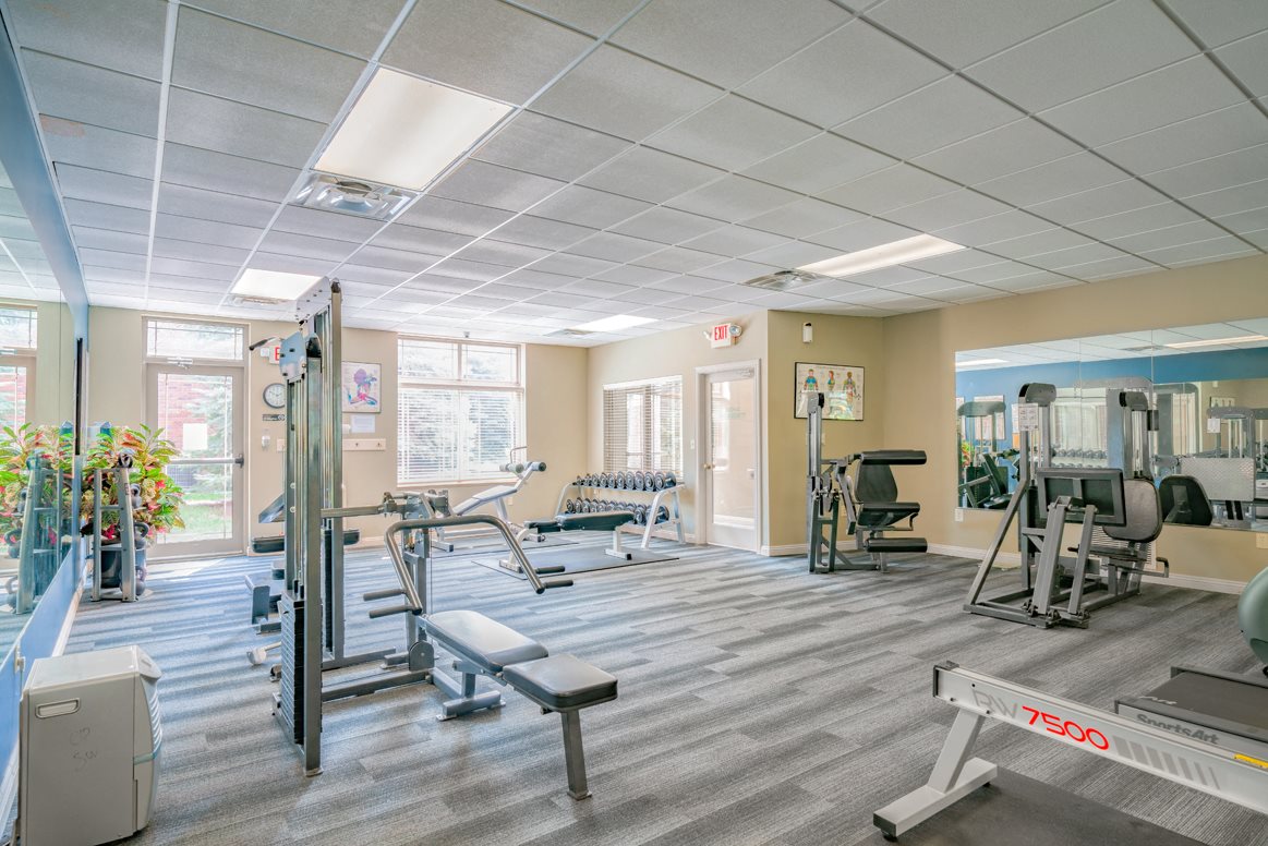 Spacious exercise room featuring cardio machines, free weights, and weightlifting machines at Southwind Villas in LaVista NE 68128