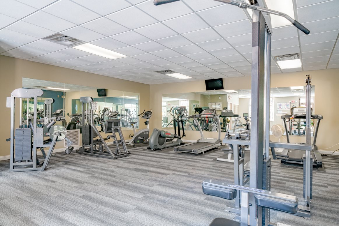 Spacious exercise room featuring cardio machines, free weights, and weightlifting machines at Southwind Villas in LaVista NE 68128