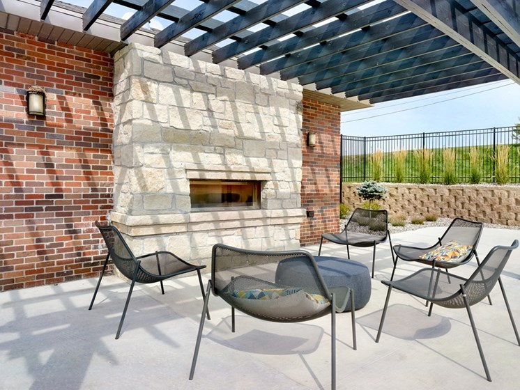 Outdoor brick fireplace with chairs positioned around it