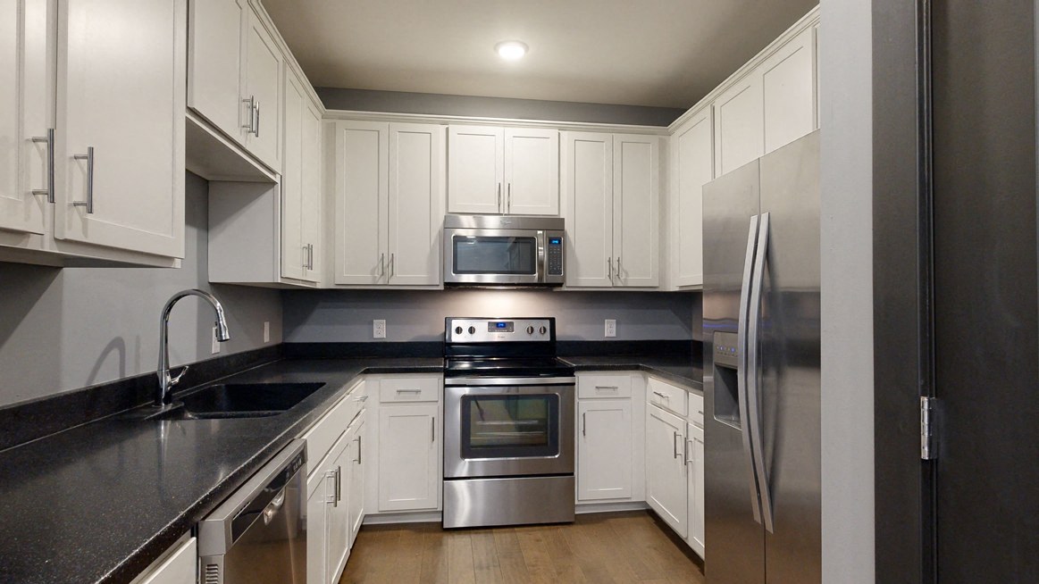 white cabinets, black trim a kitchen with white cabinets and stainless steel appliances