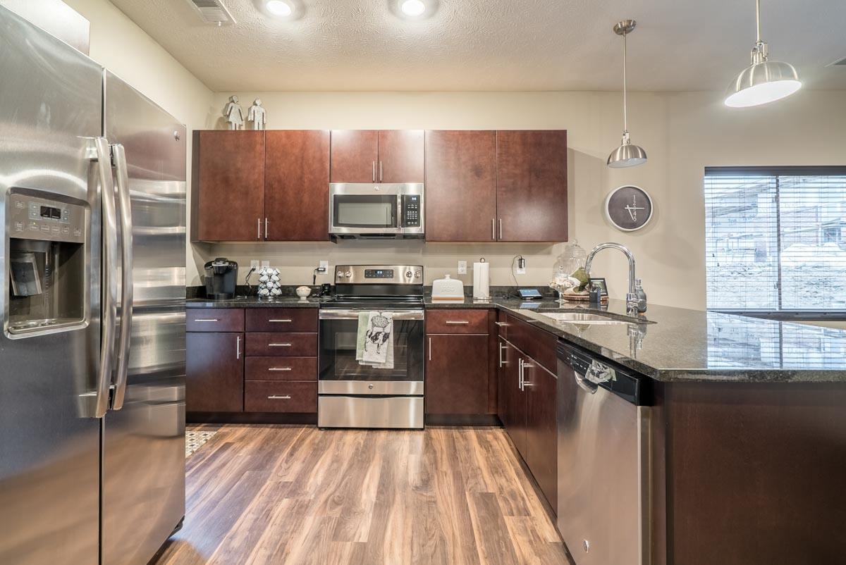 a kitchen with cherry cabinets, a stove, refrigerator and sink