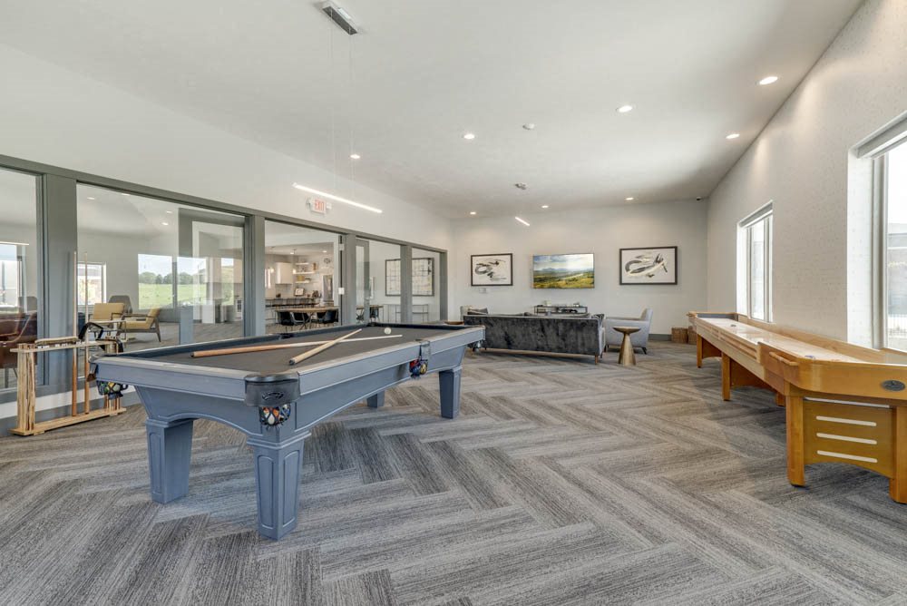 Large game room including TVs, pool tables, and shuffle board at The Villas at Mahoney Park