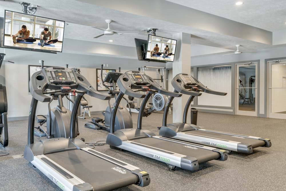 Fitness center including TVs at The Villas at Mahoney Park