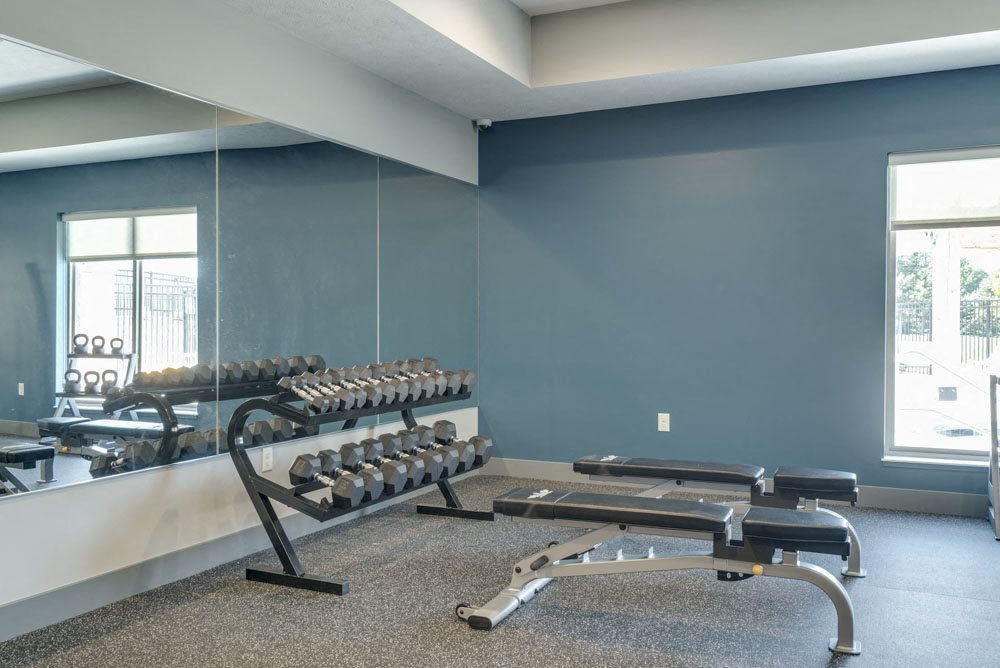 Free weights and benches in the 24 hour fitness center at The Villas at Mahoney Park