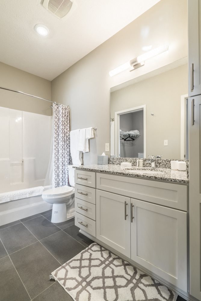 Bathroom with granite counter tops and gray slate flooring at The Villas at Mahoney Park