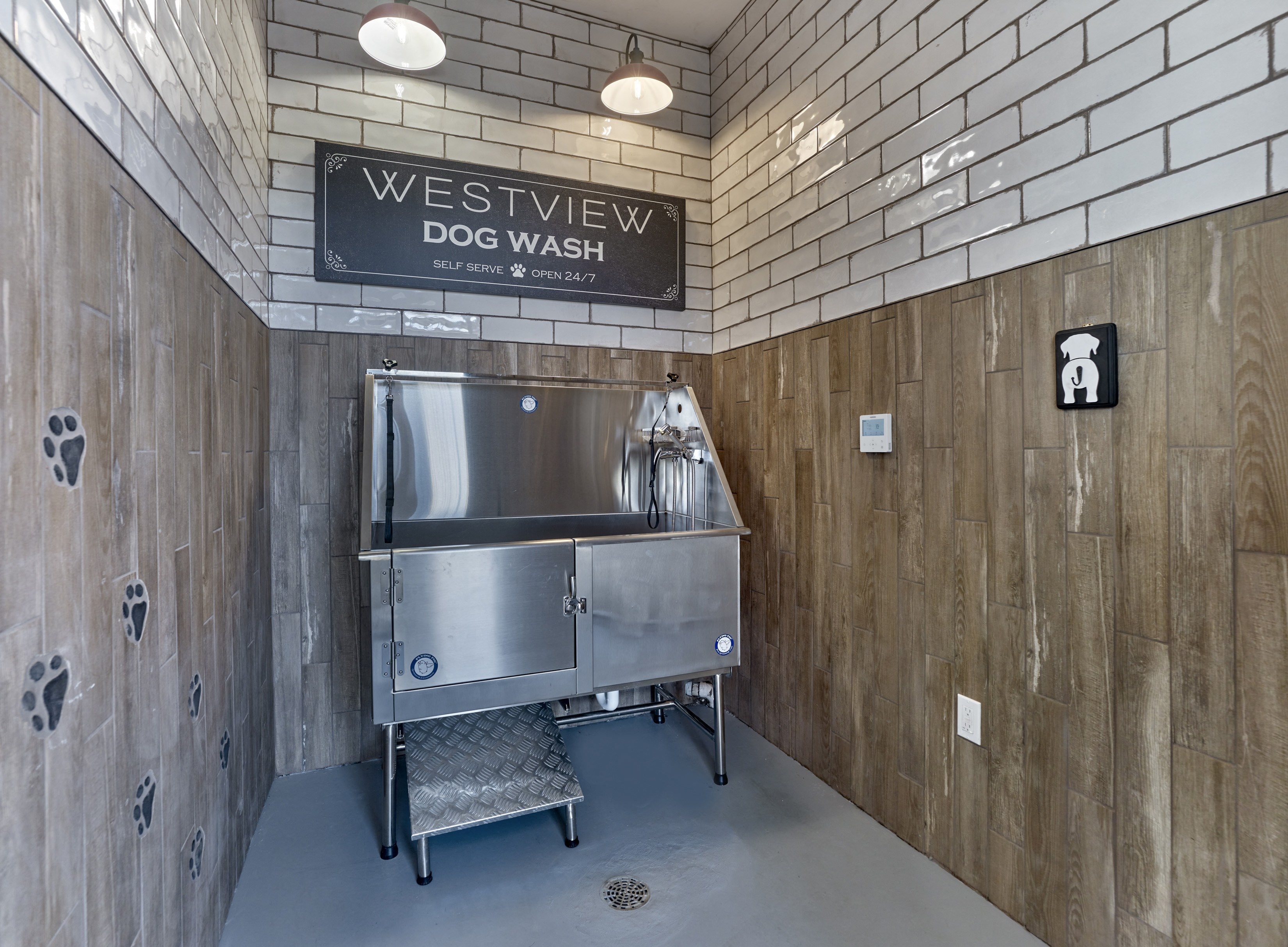 a dog wash area with a stainless steel machine in the center of the room