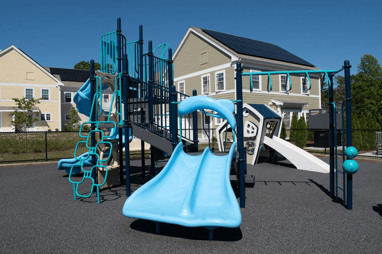 a playground with a blue slide and climbing equipment
