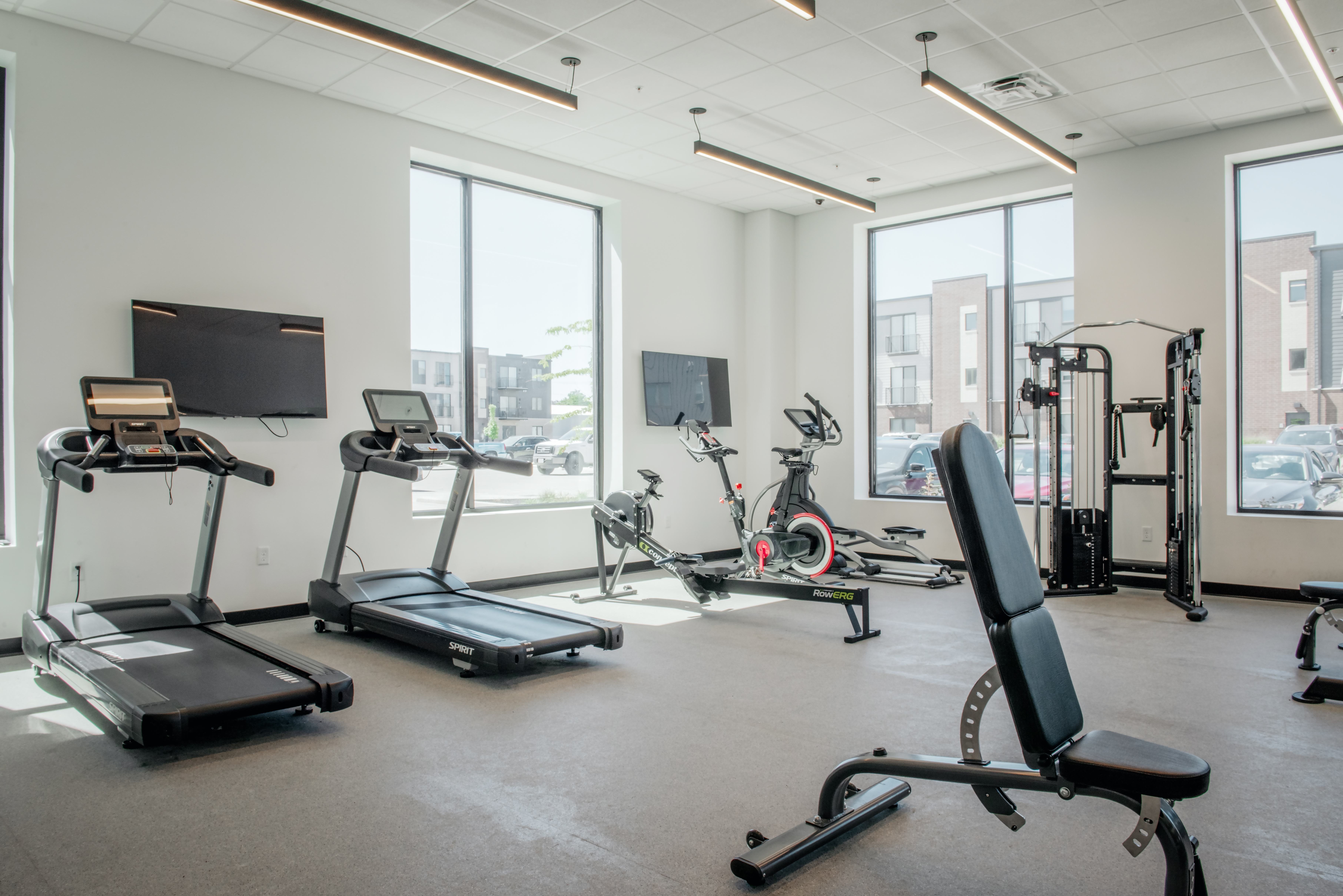 A gym with treadmills, exercise bikes, and other equipment.