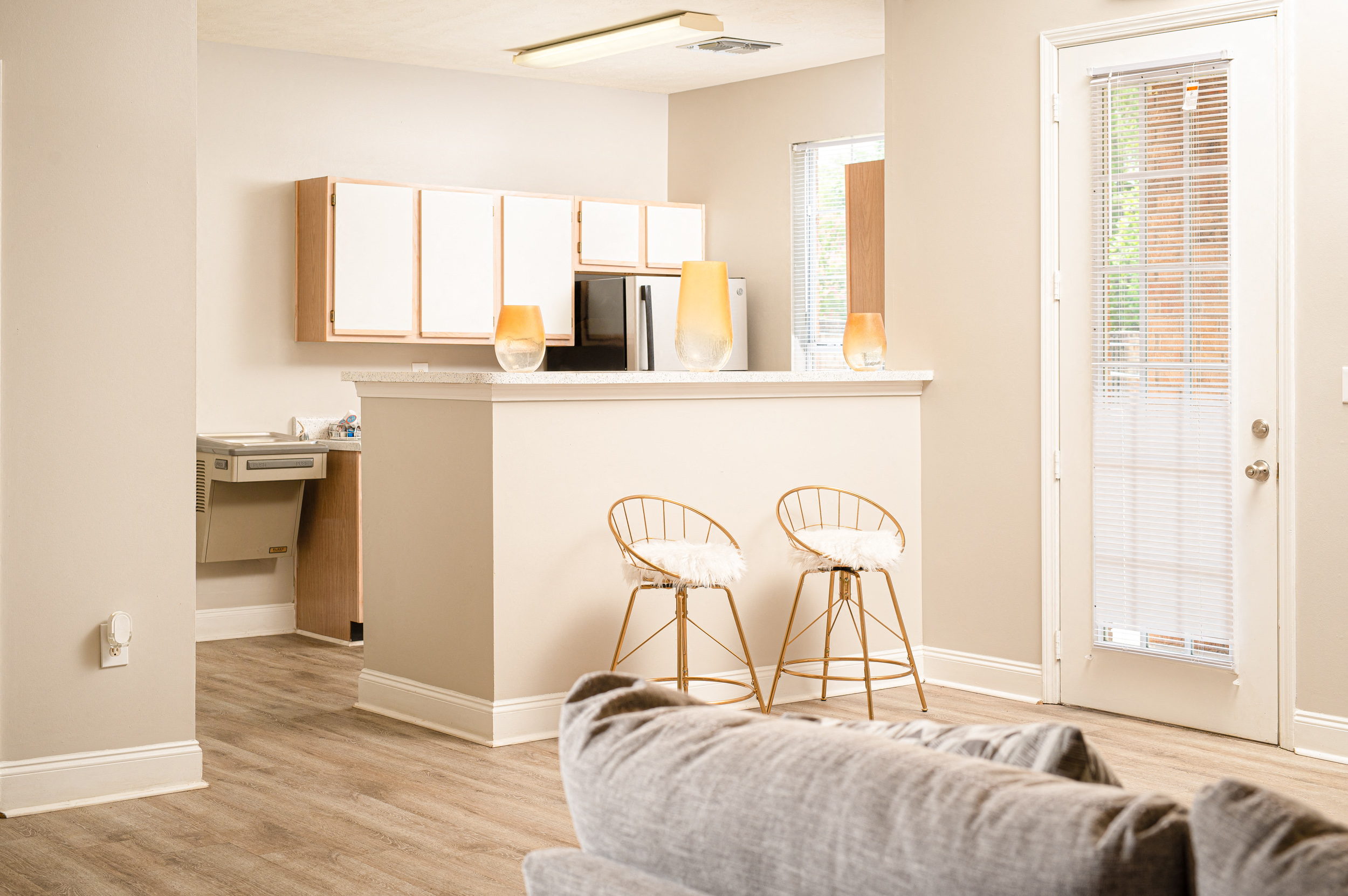 a living room with a kitchen in the background