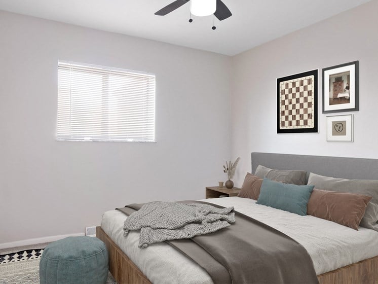 a bedroom with a ceiling fan and a window with a blind