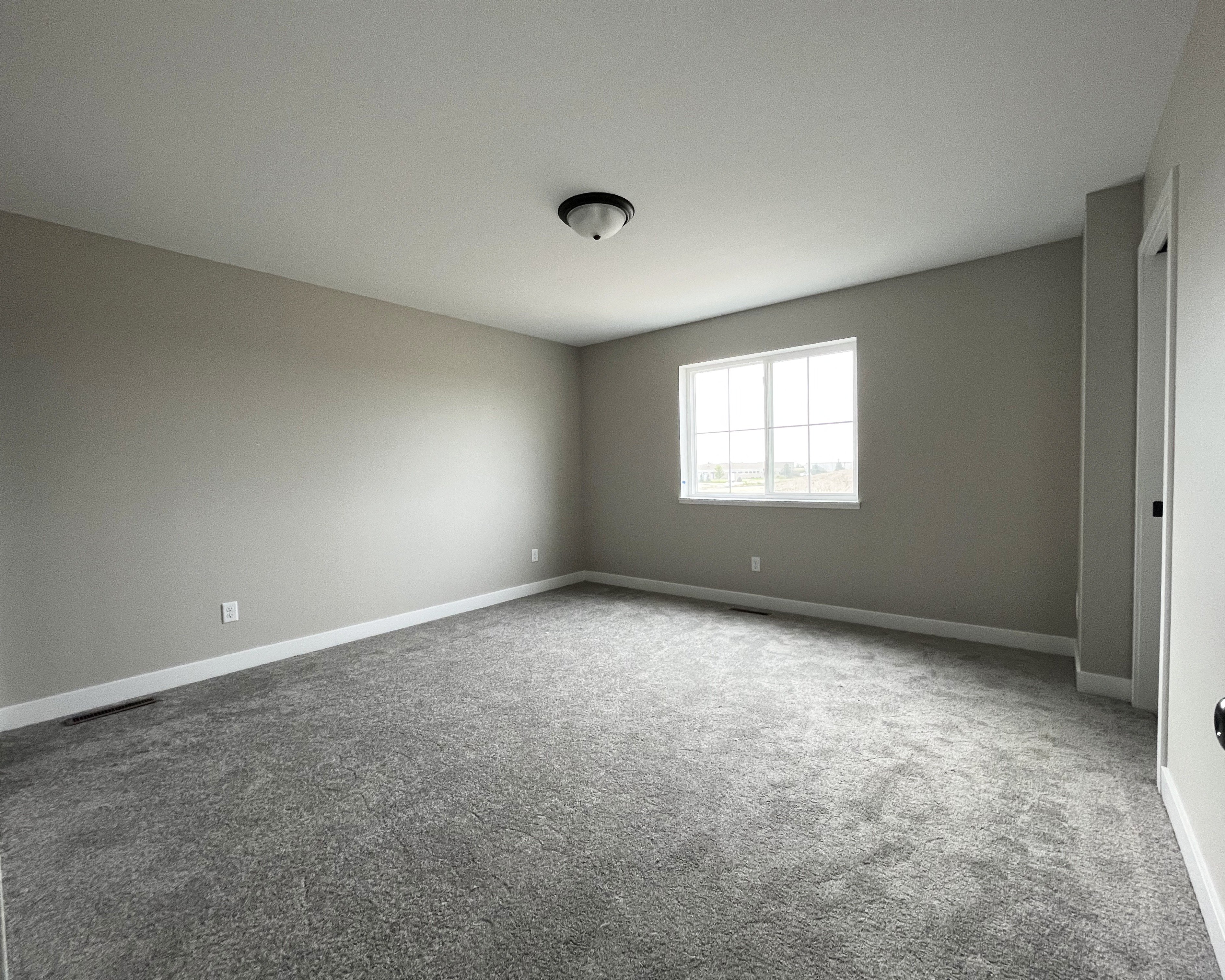 an empty room with gray walls and a white door