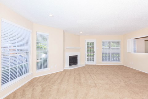 carpeted living area with windows and fireplace