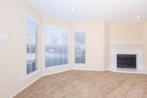 carpeted living area with windows and fireplace