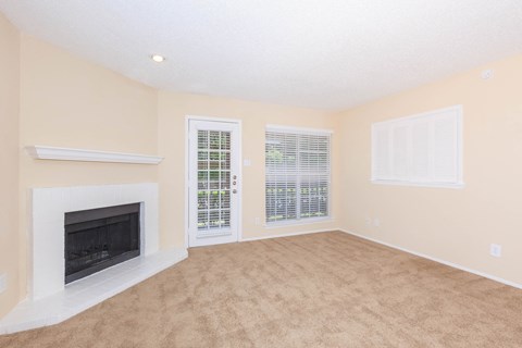 carpeted living area with window and fireplace