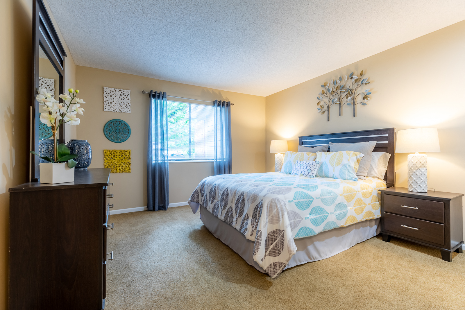 Bedroom with cozy bed and lampsat Preston Court Apartments, Overland Park