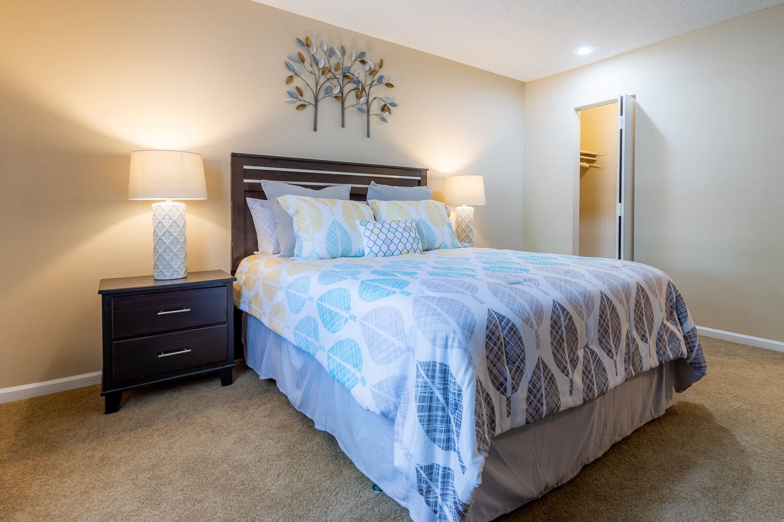 Bedroom with cozy bed and lamps1 with closetat Preston Court Apartments, Kansas, 66212