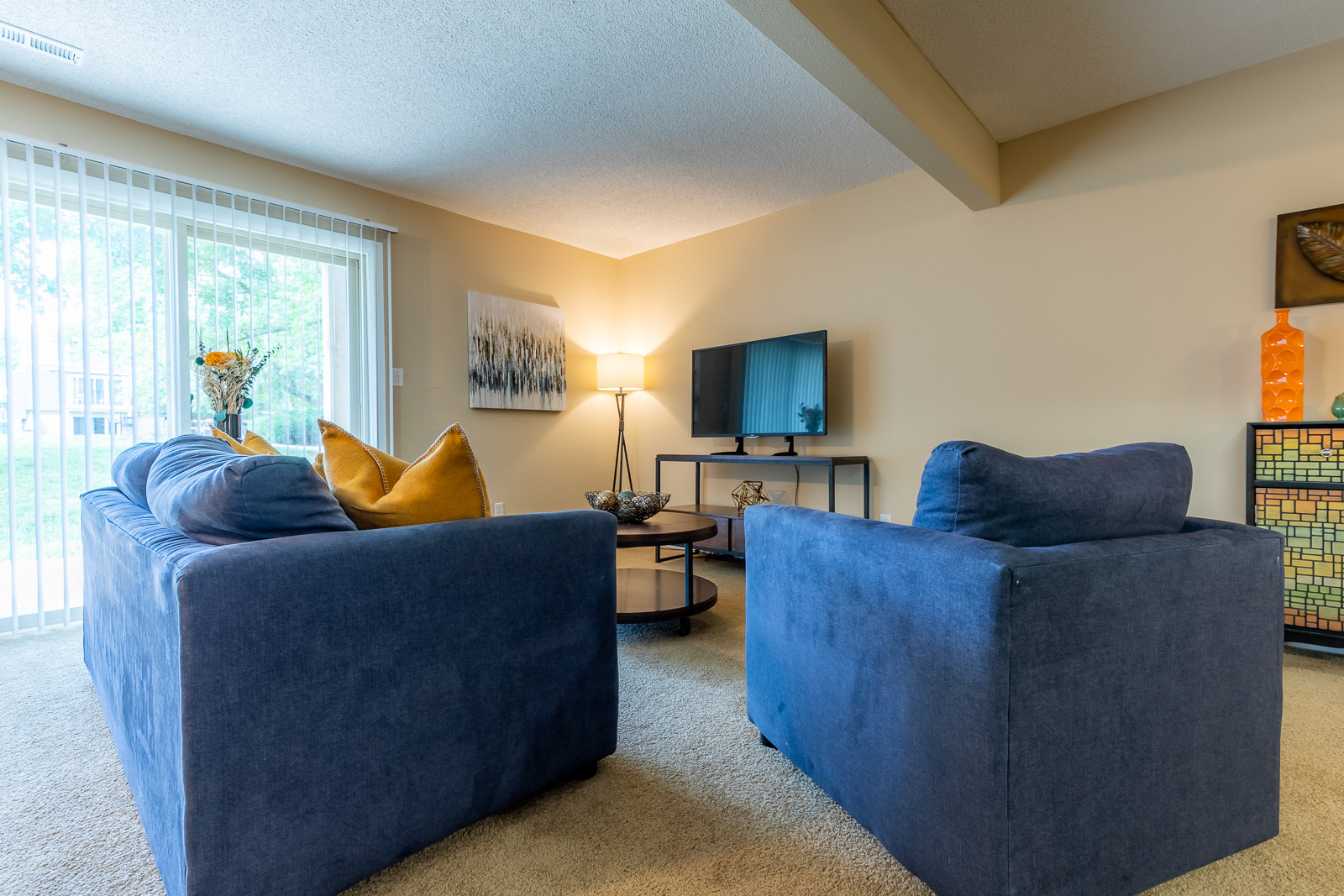 Living room with blue couch and tvat Preston Court Apartments, Overland Park, KS, 66212