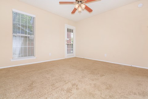 carpeted room with ceiling fan