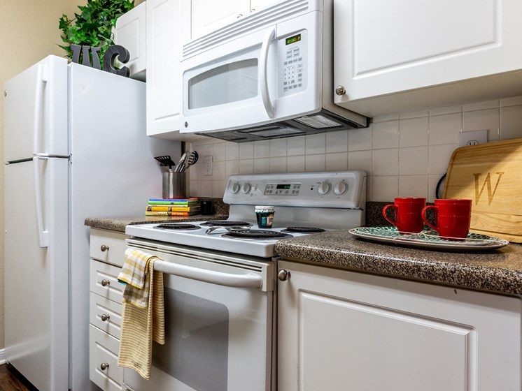 kitchen in one bedroom apartment that shows stove and built-in microwave