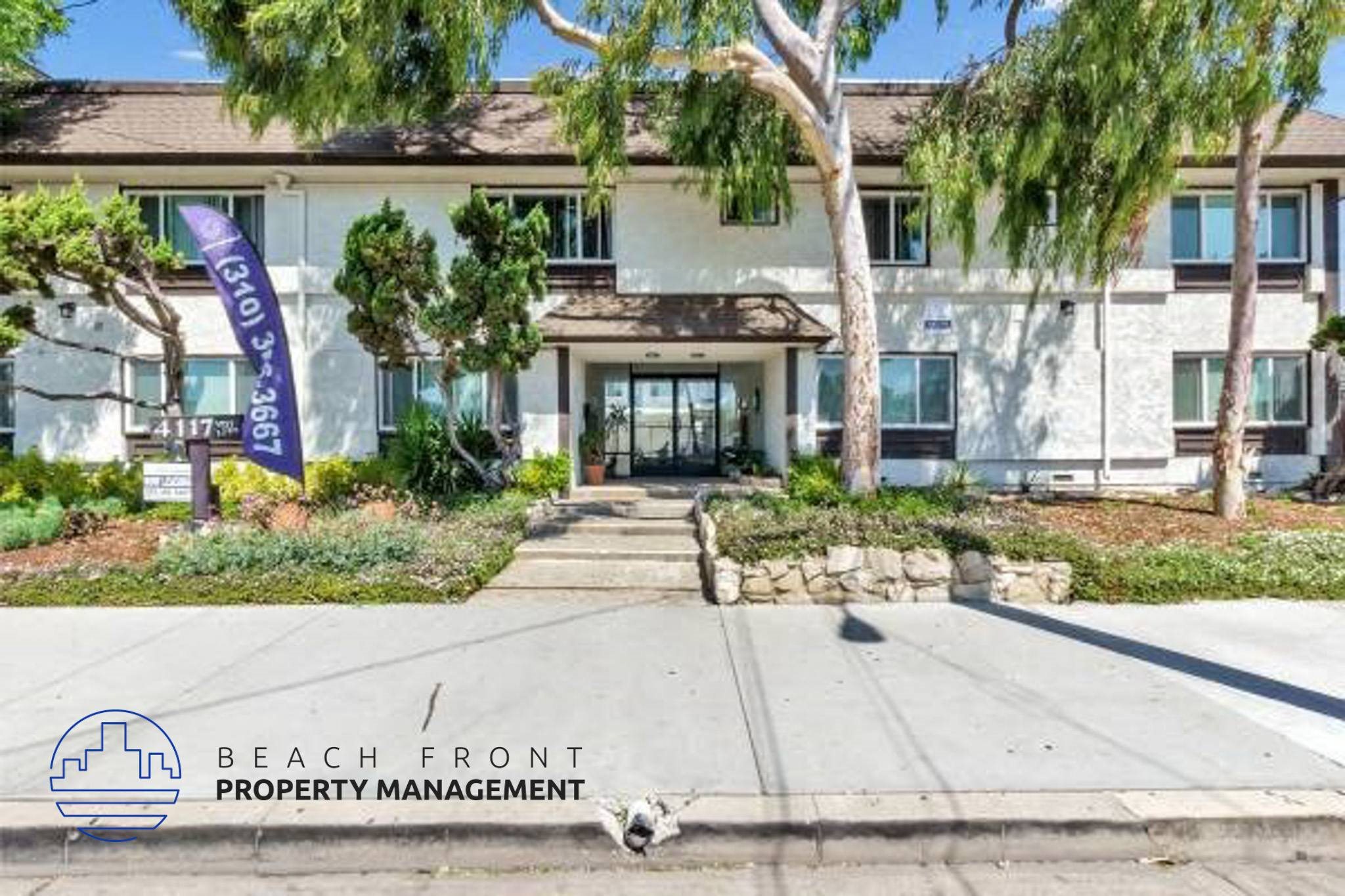 a beach front property management building with a dog in front of it