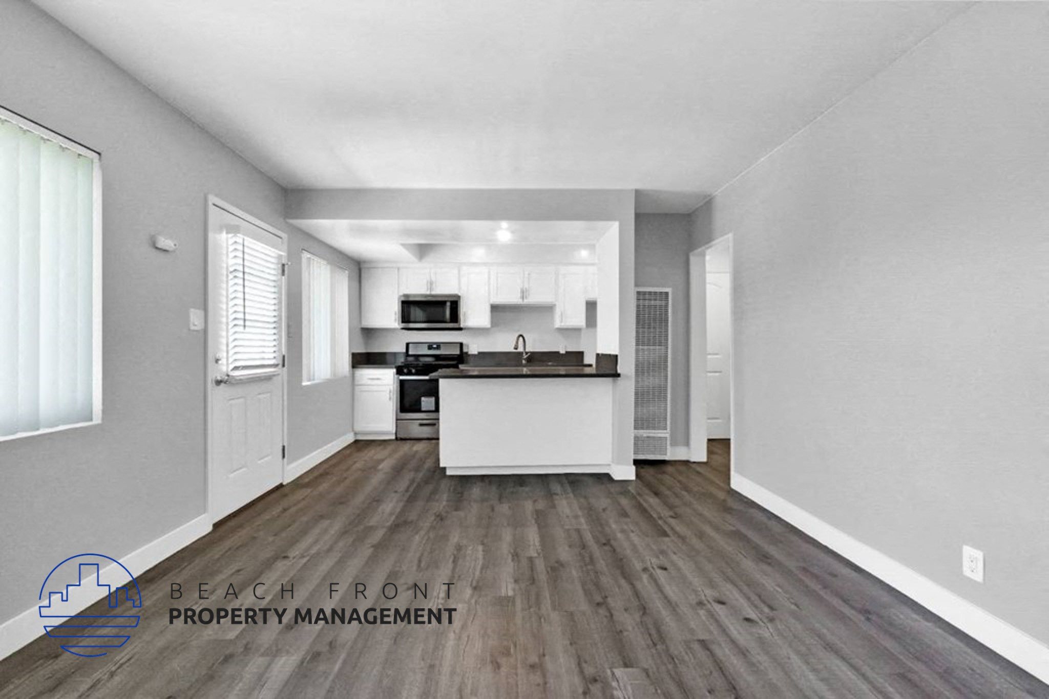 an open kitchen and living room with white walls and wood floors