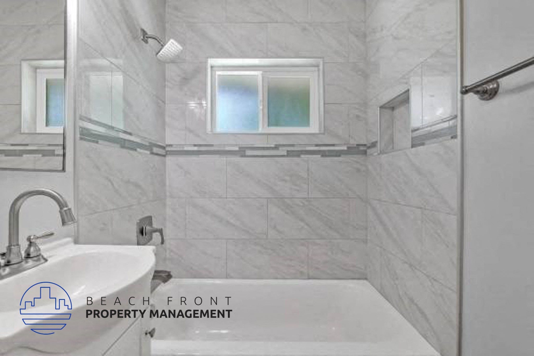 A bathroom with a marble tile wall and a white sink.