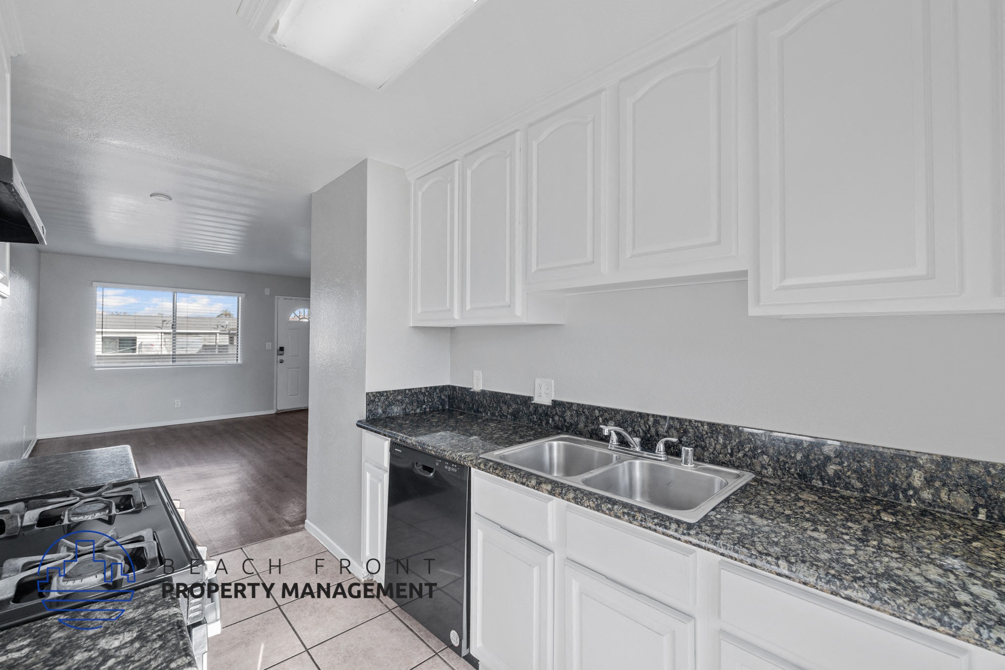 A kitchen with granite countertops and white cabinets.