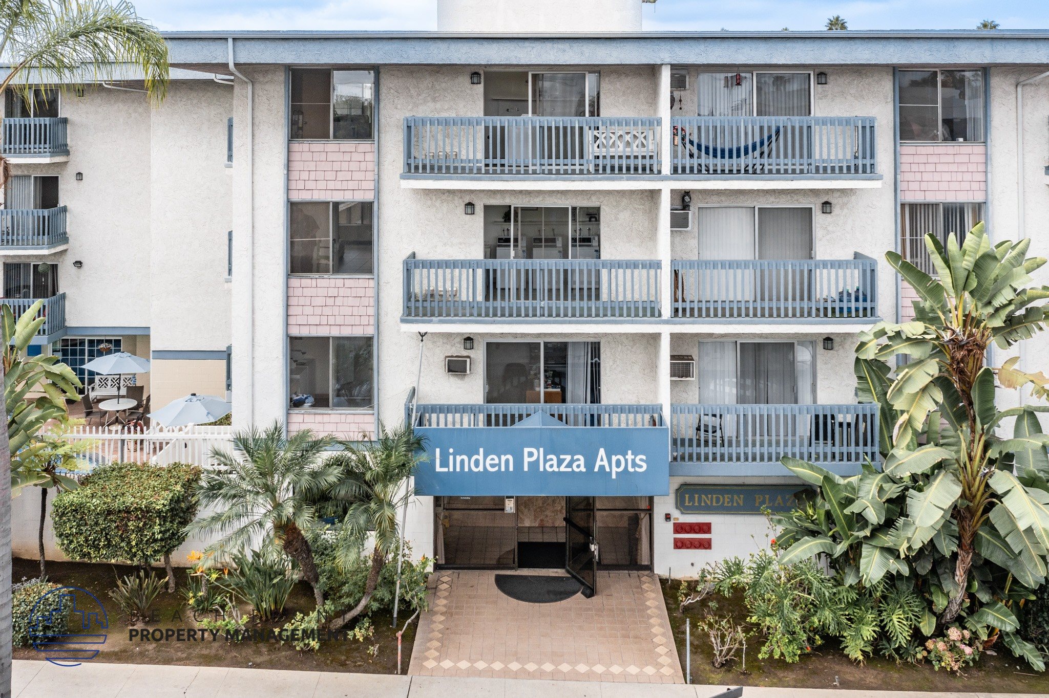 Linden Plaza Apts is a white apartment complex with a blue sign in front.