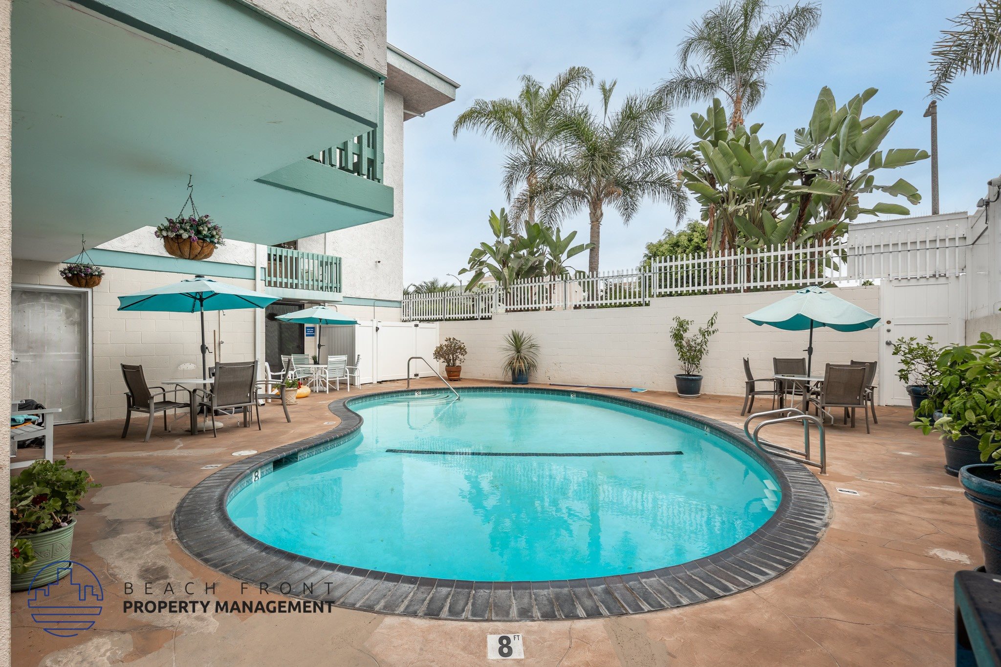 A pool surrounded by chairs and umbrellas with a sign that says