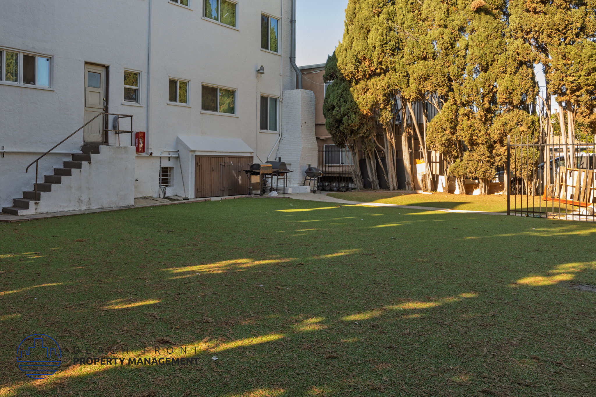 A white building with a green lawn in front of it.