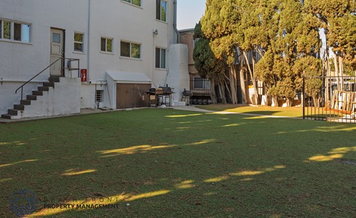 A white building with a green lawn in front of it.