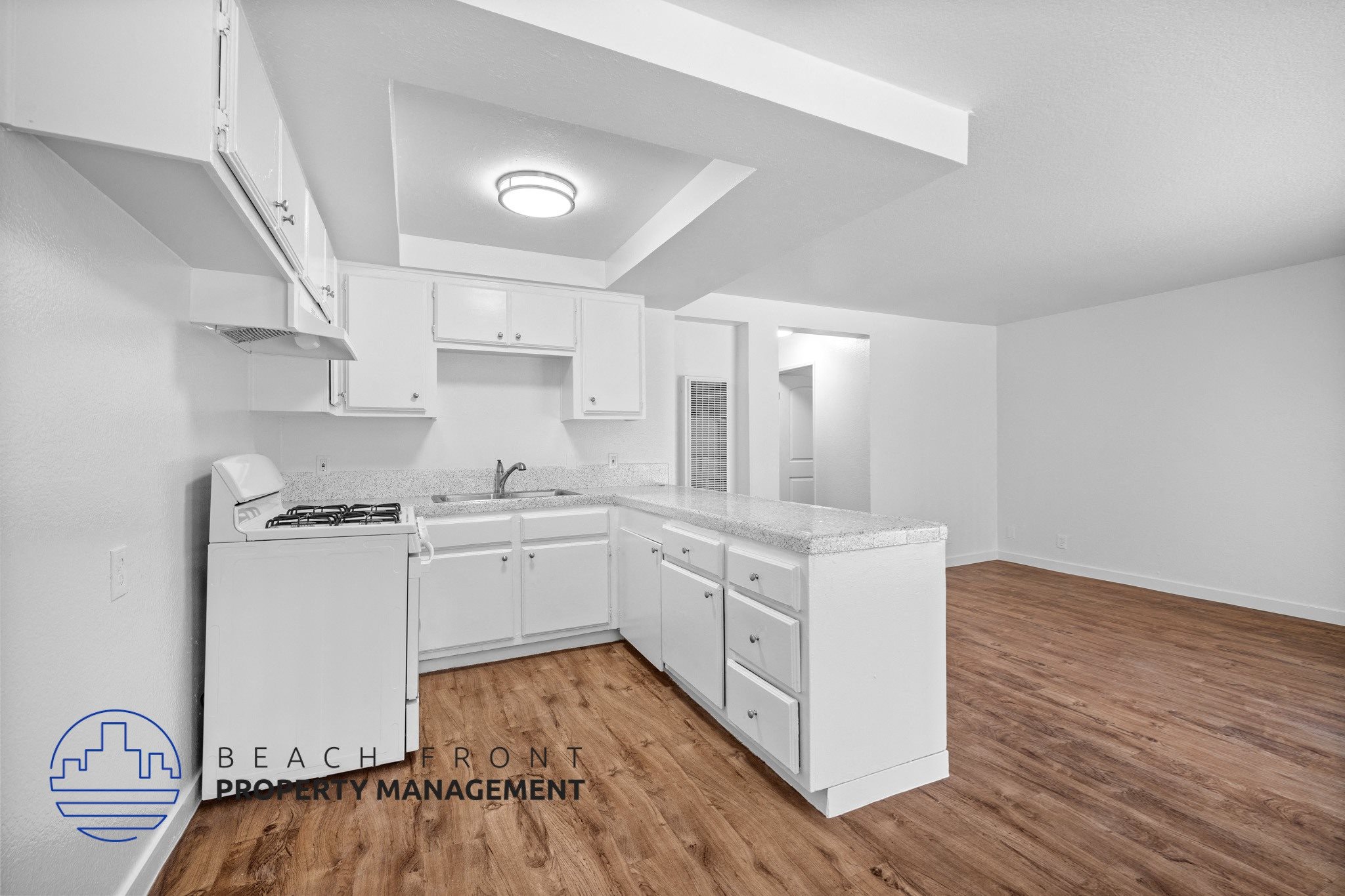 a white kitchen with a wooden floor and white cabinets,a white kitchen with a wooden floor and white cabinets