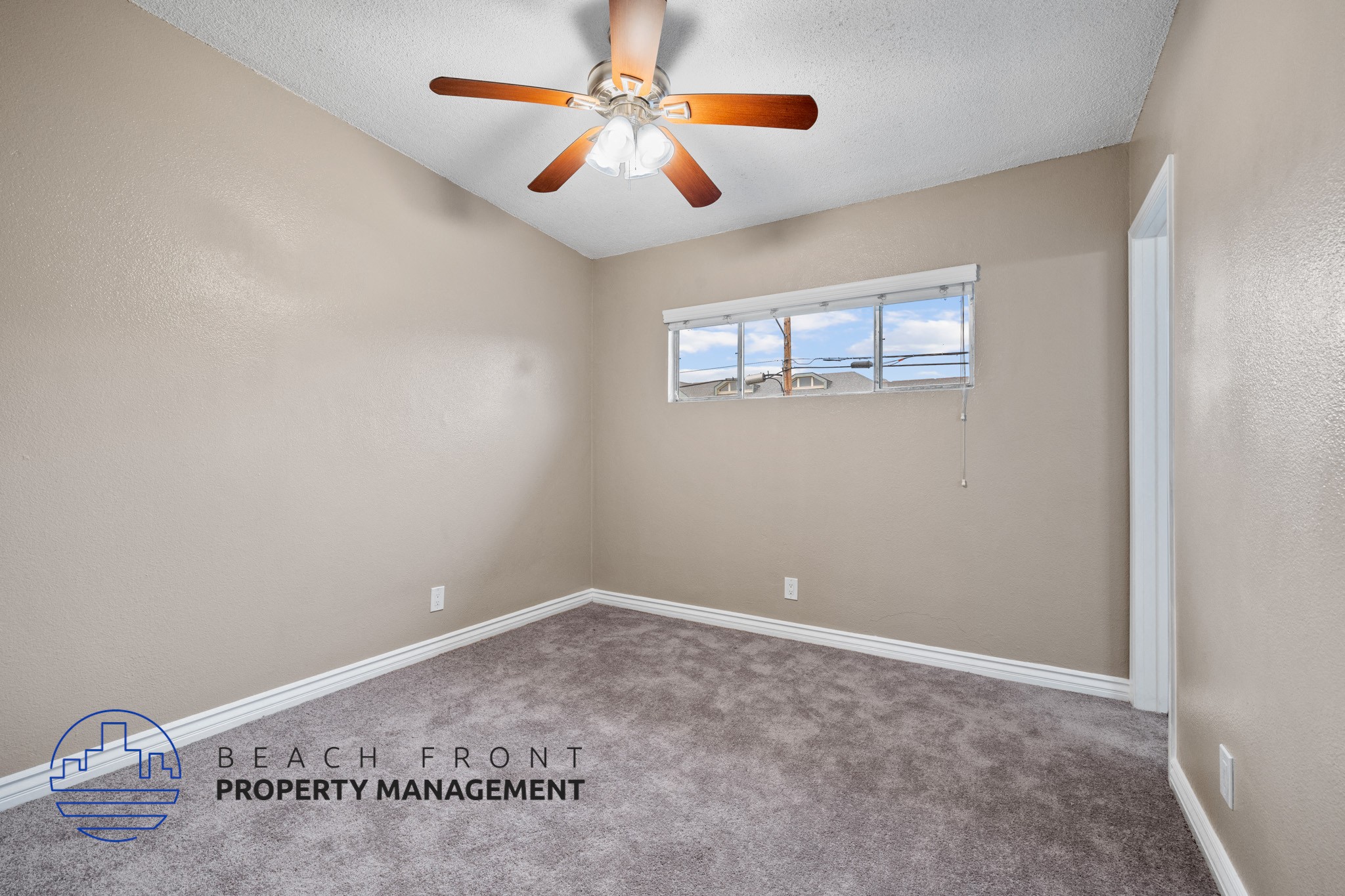 A room with a ceiling fan and a window.