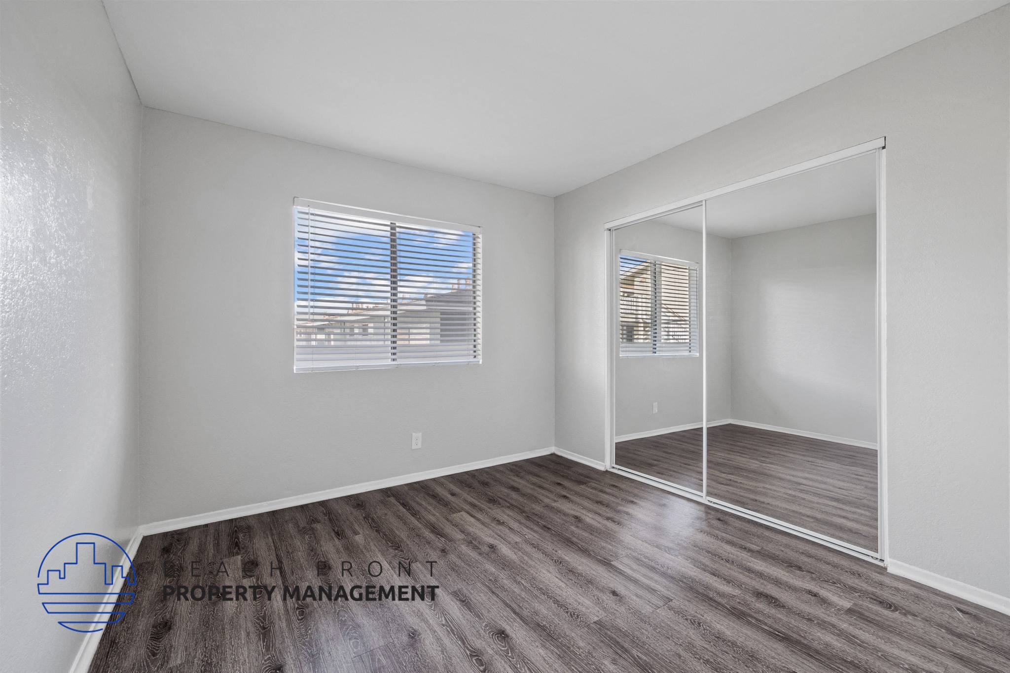 A room with a window and a wooden floor.