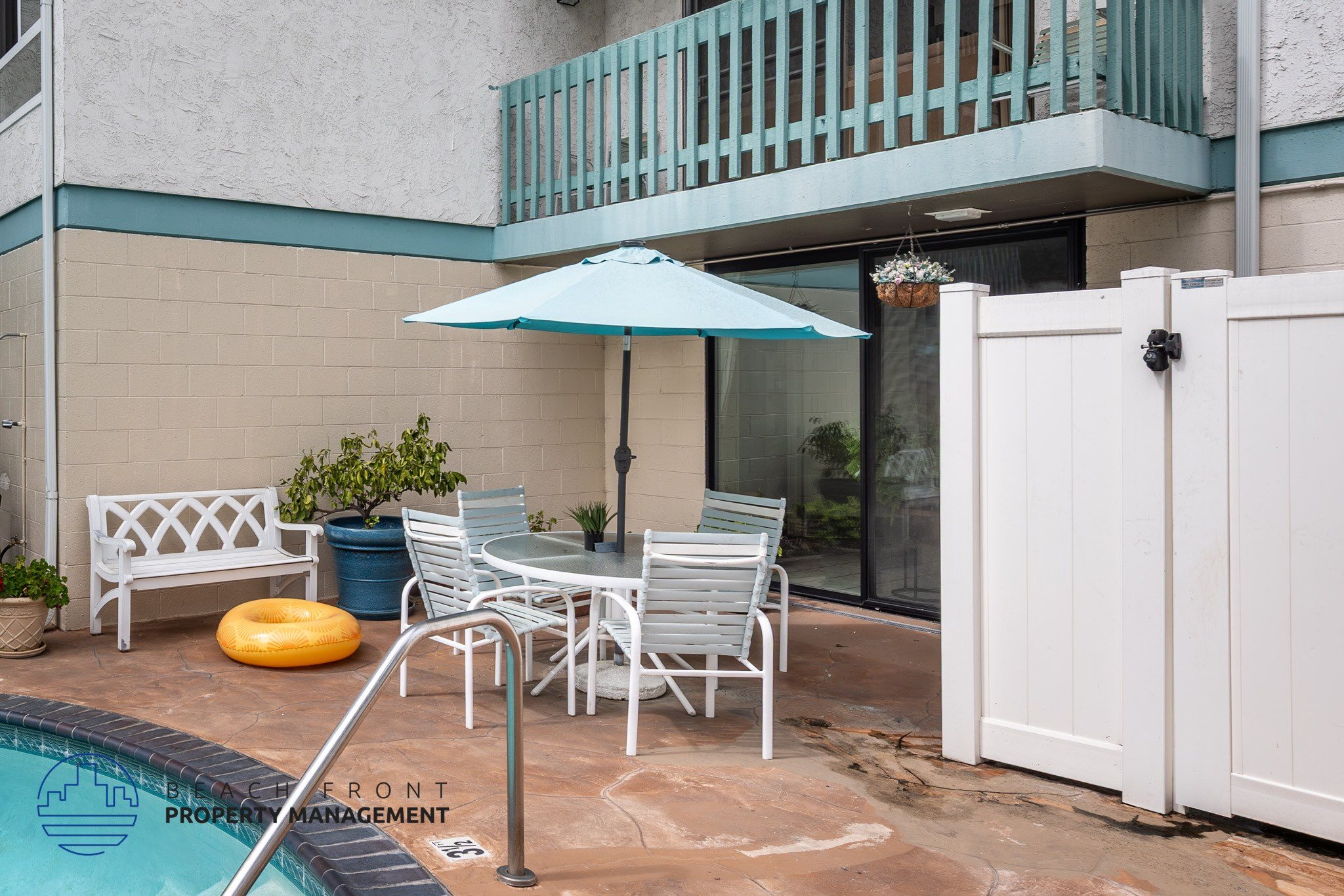A poolside patio with a white table and chairs.